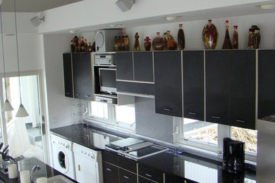 Enclosed kitchen - galley enclosed kitchen idea in St Louis with a drop-in sink, flat-panel cabinets, white cabinets and no island