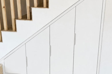 Cette photo montre un petit placard dressing tendance avec un placard à porte plane et des portes de placard blanches.