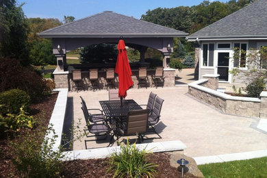 Patio - large modern backyard concrete paver patio idea in Other