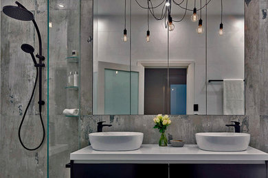 This is an example of a small industrial bathroom in Adelaide with black cabinets, a freestanding tub, an open shower, a wall-mount toilet, porcelain tile, porcelain floors and a vessel sink.