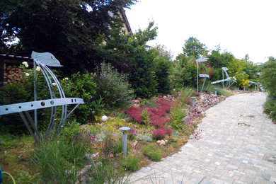 Mittelgroße Moderne Gartenmauer im Sommer, neben dem Haus mit direkter Sonneneinstrahlung und Natursteinplatten in Berlin