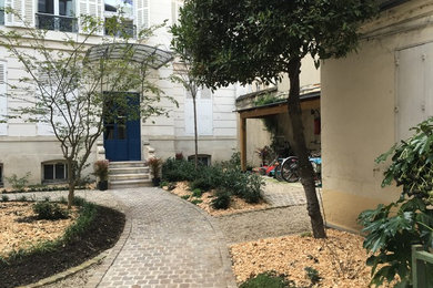 パリにある高級な中くらいなトランジショナルスタイルのおしゃれな中庭 (半日向、マルチング舗装) の写真