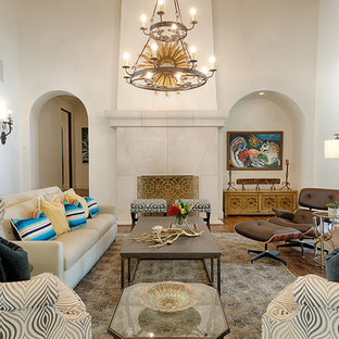 Fernseherloses, Offenes Mediterranes Wohnzimmer mit weißer Wandfarbe, braunem Holzboden, Kaminofen und Kaminsims aus Stein in Austin