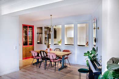 Cette image montre une salle à manger ouverte sur le salon traditionnelle avec un mur blanc, sol en stratifié et un sol marron.