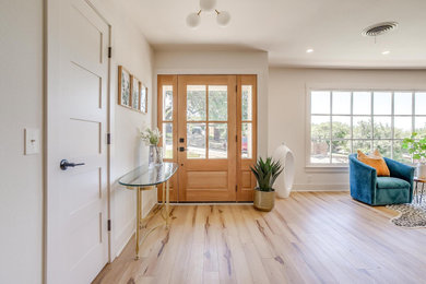 Inspiration for a mid-sized 1950s vinyl floor and brown floor entryway remodel in Dallas with white walls and a light wood front door