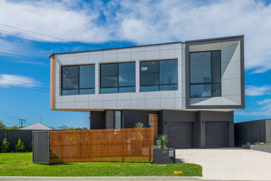Contemporary multi-coloured house exterior in Central Coast with a flat roof and a metal roof.