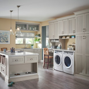 This is an example of a traditional utility room in Minneapolis with a built-in sink, dark hardwood flooring, a side by side washer and dryer, recessed-panel cabinets, grey cabinets and beige walls.