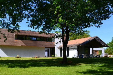 Réalisation d'une très grande façade de maison grise design en bois à un étage.