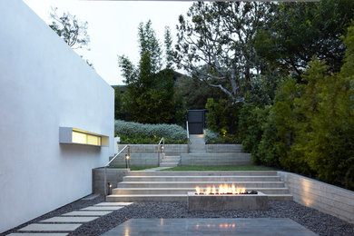 Inspiration for a mid-sized modern front yard partial sun garden for spring in Los Angeles with a fire feature and gravel.