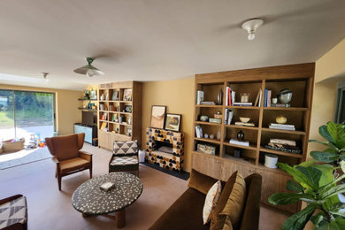 サリーにある高級な中くらいなコンテンポラリースタイルのおしゃれなLDK (ライブラリー、黄色い壁、セラミックタイルの床、標準型暖炉、タイルの暖炉まわり、コーナー型テレビ、ベージュの床) の写真