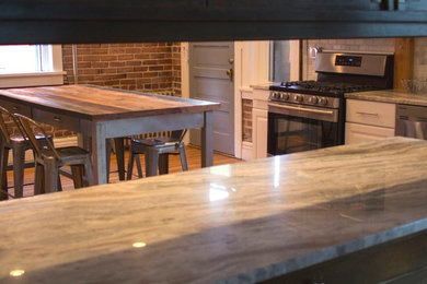 Enclosed kitchen - mid-sized eclectic u-shaped medium tone wood floor enclosed kitchen idea in Denver with an undermount sink, raised-panel cabinets, white cabinets, granite countertops, white backsplash, stone tile backsplash, stainless steel appliances and an island