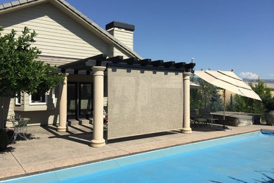 This is an example of a large traditional backyard patio in Seattle with concrete slab and a pergola.