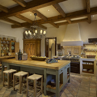 Mediterranean kitchen pantry appliance - Example of a tuscan kitchen pantry design in Phoenix with beige backsplash, stainless steel appliances and an island