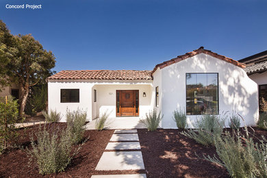 Modelo de fachada de casa blanca mediterránea de tamaño medio de una planta con revestimiento de estuco, tejado plano y tejado de teja de barro