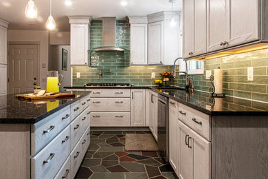 Eat-in kitchen - large transitional l-shaped slate floor and multicolored floor eat-in kitchen idea with an undermount sink, recessed-panel cabinets, white cabinets, granite countertops, green backsplash, ceramic backsplash, stainless steel appliances, an island and black countertops