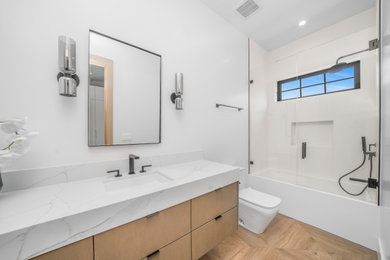 Bathroom - modern kids' white tile light wood floor, brown floor and single-sink bathroom idea in Los Angeles with light wood cabinets, quartz countertops, a hinged shower door, white countertops and a niche