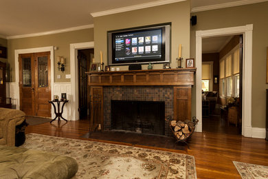 Inspiration for a large timeless enclosed medium tone wood floor living room remodel in New York with beige walls, a standard fireplace, a tile fireplace and a wall-mounted tv