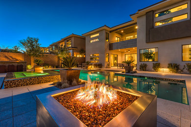 Large island style backyard stone and rectangular lap hot tub photo in Las Vegas