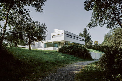 Design ideas for an expansive modern white house exterior in Stuttgart with concrete fiberboard siding and a flat roof.