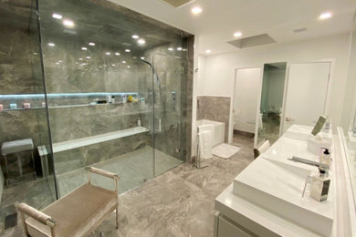 Bathroom - large modern master gray tile and marble tile double-sink bathroom idea in New York with flat-panel cabinets, white cabinets, quartz countertops, a hinged shower door, white countertops and a built-in vanity