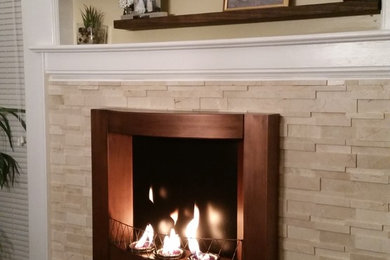 Example of a mid-sized classic medium tone wood floor great room design in New York with beige walls, a standard fireplace and a stone fireplace