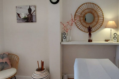 Imagen de estudio de yoga exótico pequeño con paredes blancas y suelo de madera en tonos medios
