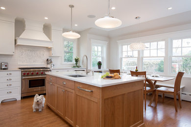 Design ideas for a large transitional l-shaped eat-in kitchen in Boston with an undermount sink, shaker cabinets, white cabinets, quartz benchtops, white splashback, porcelain splashback, stainless steel appliances, medium hardwood floors, with island, brown floor and beige benchtop.