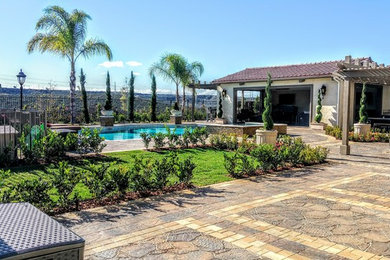 This is an example of a large mediterranean full sun backyard concrete paver landscaping in San Diego for summer.