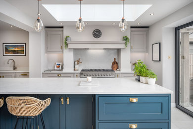 Design ideas for an expansive modern open plan kitchen in Berkshire with an integrated sink, beaded cabinets, quartz worktops, white splashback, marble splashback, stainless steel appliances, an island and white worktops.