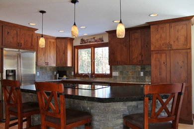 Inspiration for a mid-sized rustic l-shaped eat-in kitchen remodel in Denver with an undermount sink, flat-panel cabinets, distressed cabinets, granite countertops, gray backsplash, stone tile backsplash, stainless steel appliances and an island