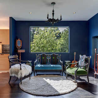 Exemple d'un hall d'entrée éclectique avec un mur bleu, un sol en bois foncé, une porte simple, une porte en bois clair et un sol marron.