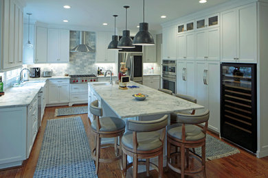 Eat-in kitchen - traditional l-shaped medium tone wood floor and brown floor eat-in kitchen idea in Other with an undermount sink, shaker cabinets, white cabinets, marble countertops, gray backsplash, marble backsplash, stainless steel appliances, an island and gray countertops