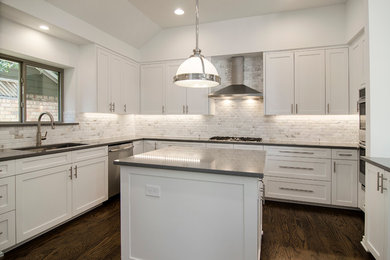 This is an example of a mid-sized transitional u-shaped eat-in kitchen in Dallas with an undermount sink, shaker cabinets, white cabinets, quartzite benchtops, white splashback, matchstick tile splashback, stainless steel appliances, dark hardwood floors and with island.