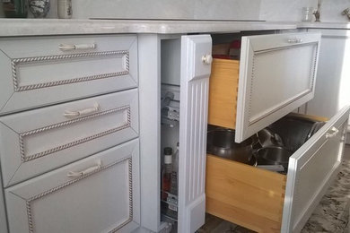 Diseño de cocinas en L de tamaño medio cerrada con armarios con paneles empotrados, puertas de armario beige, encimera de madera y salpicadero beige