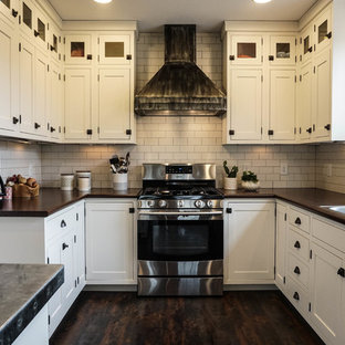 Réalisation d'une petite arrière-cuisine champêtre en U avec un évier posé, un placard à porte shaker, des portes de placard blanches, une crédence blanche, une crédence en carrelage métro, un électroménager en acier inoxydable, un sol en bois foncé, un îlot central, un sol marron et un plan de travail en zinc.