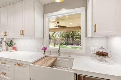 Mid-sized french country kitchen photo in Austin with a farmhouse sink, white cabinets, quartz countertops, white backsplash, ceramic backsplash, stainless steel appliances, an island and white countertops