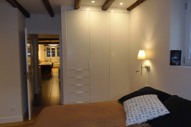 Réalisation d'une chambre parentale design de taille moyenne avec un mur blanc, parquet clair et un sol beige.