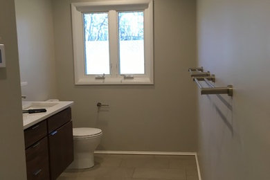 Inspiration for a porcelain tile bathroom remodel in DC Metro with flat-panel cabinets, dark wood cabinets and quartz countertops