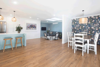 Mid-sized farmhouse laminate floor, brown floor and wallpaper kitchen/dining room combo photo in Hamilton with white walls