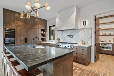 Kitchen - cottage u-shaped light wood floor and beige floor kitchen idea in Other with an undermount sink, flat-panel cabinets, medium tone wood cabinets, white backsplash, stone slab backsplash, stainless steel appliances, an island and white countertops