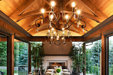 Идея дизайна: столовая в классическом стиле с стандартным камином, фасадом камина из камня и балками на потолке