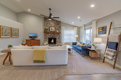 Family room - mid-sized eclectic open concept carpeted, beige floor and vaulted ceiling family room idea in Portland with gray walls, a standard fireplace, a stacked stone fireplace and a tv stand