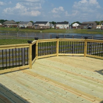 Octagonal wood deck with black aluminum balusters, and solar post caps