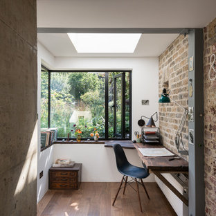 Idéer för industriella arbetsrum, med vita väggar, mörkt trägolv och ett inbyggt skrivbord