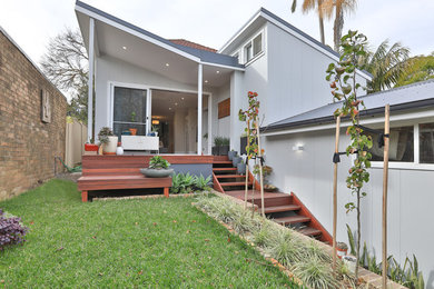Photo of a traditional one-storey grey house exterior in Sydney with concrete fiberboard siding, a gable roof and a metal roof.