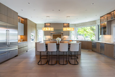 Inspiration for a contemporary kitchen remodel in Portland with medium tone wood cabinets, quartz countertops, beige backsplash, quartz backsplash, stainless steel appliances, an island and beige countertops