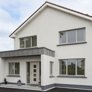 На фото: одноэтажные фасады дуплексов среднего размера серого цвета в стиле модернизм с облицовкой из дерева и двускатной крышей