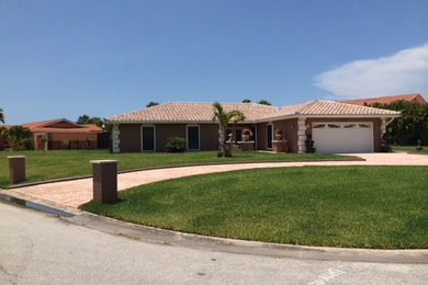 Inspiration for a mid-sized mediterranean beige one-story stucco exterior home remodel in Tampa with a hip roof