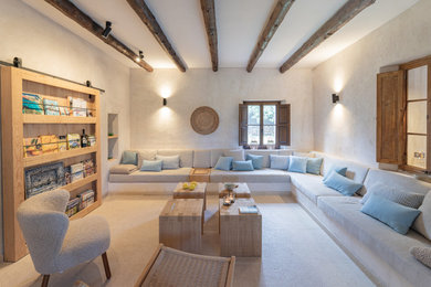 Großes, Offenes Mediterranes Wohnzimmer mit beiger Wandfarbe, Travertin, verstecktem TV, beigem Boden und freigelegten Dachbalken in Palma de Mallorca