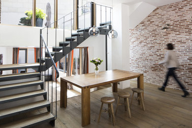 Inspiration pour une salle à manger ouverte sur le salon design de taille moyenne avec un mur blanc, un sol en bois brun et un sol marron.